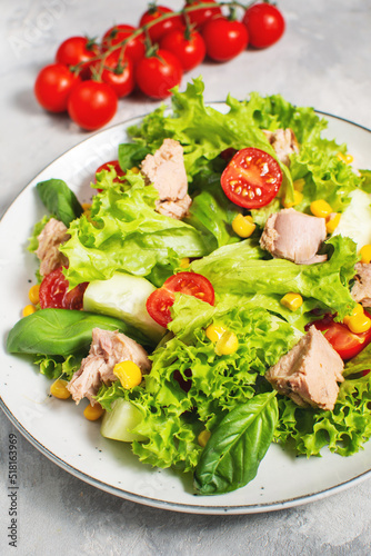 Tuna Fish Salad with Lettuce, Cherry Tomatoes, Cucumber and Corn on concrete background