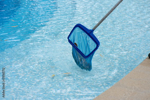 Close Up Workers are using a grid to collect leaves and rubbish that have fallen into the hotel swimming pool to keep the pool ready for use.