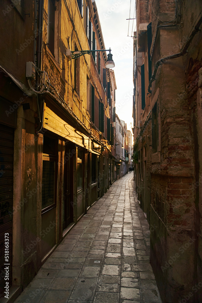 Empty dark narrow cobbled street in Venice, Italy