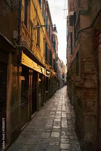 Empty dark narrow cobbled street in Venice, Italy
