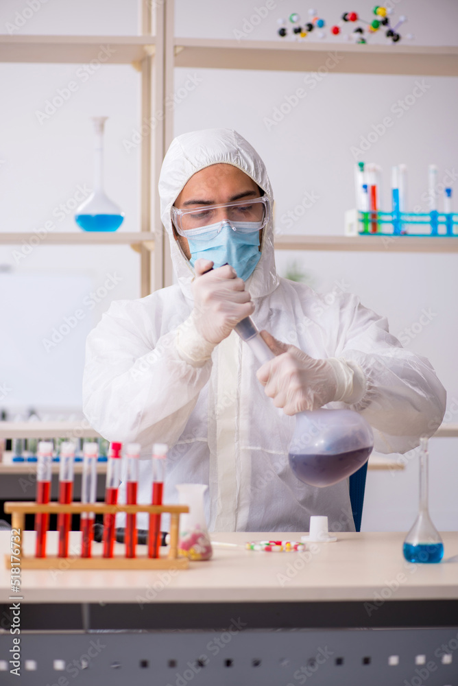 Young male chemist sitting at the lab during pandemic Young male chemist sitting at the lab during pandemic