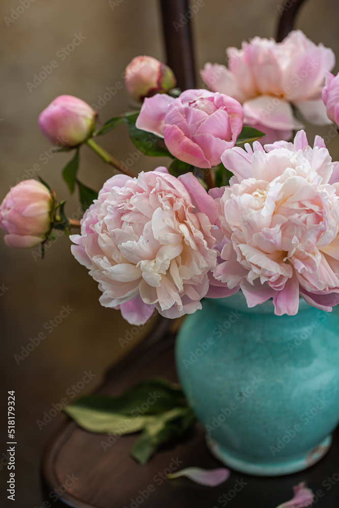 Obraz premium Bouquet of pink peonies in an old blue jug