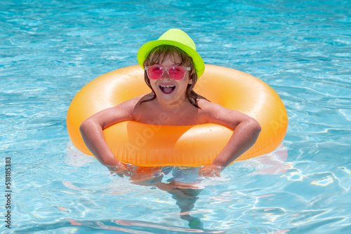 Kid boy playing with inflatable floating ring in swimming pool. Summer vacation concept. Summer kids portrait in sea water on beach.