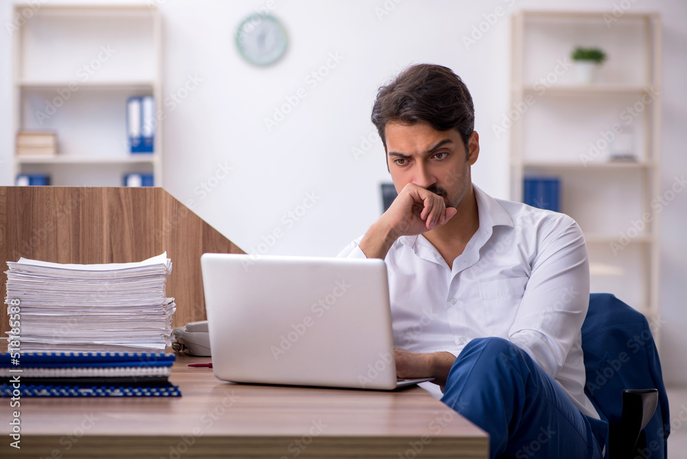 Young male employee and too much work in the office