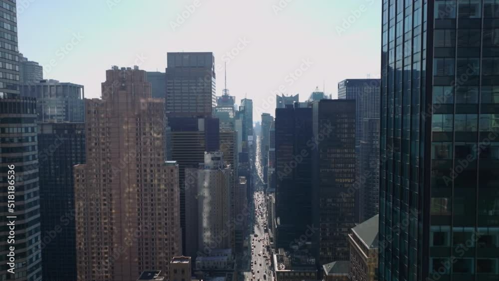 Forwards fly high above wide street sandwiched between tall office or apartment downtown buildings. Manhattan, New York City, USA Forwards fly high above wide street sandwiched between tall office or apartment downtown buildings. Manhattan, New York City, USA