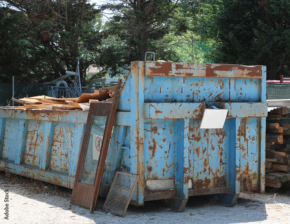 Φωτογραφία large blue container for the collection of wood and wooden window frames in the