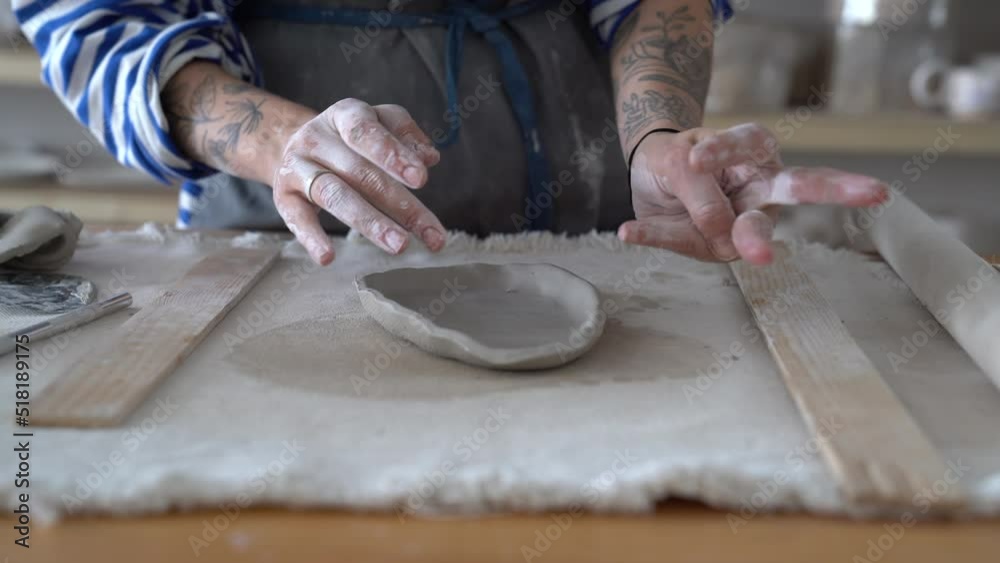 Cropped image of female potter sculpting clay pot with hands. Ceramist woman work with raw earthenware creating handmade pottery. Workplace of ceramics master. Craftsmanship and small business concept Cropped image of female potter sculpting clay pot with hands. Ceramist woman work with raw earthenware creating handmade pottery. Workplace of ceramics master. Craftsmanship and small business concept