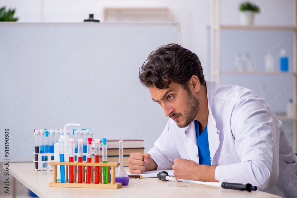 Young male chemist working at the lab Young male chemist working at the lab