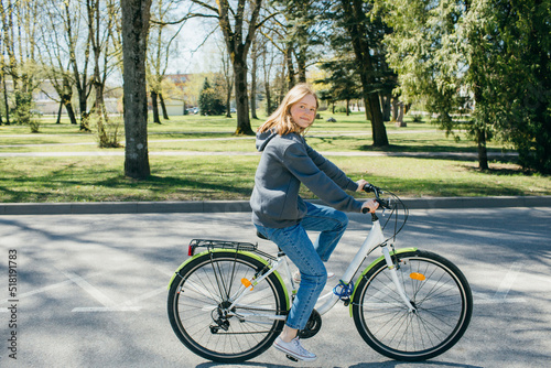 Young girl riding a bike. Sustainable mobility transport New way of inclusive cities mobility. Green transportation. Sustainable climate neutral city goals. Green mobility and transportation © Girts