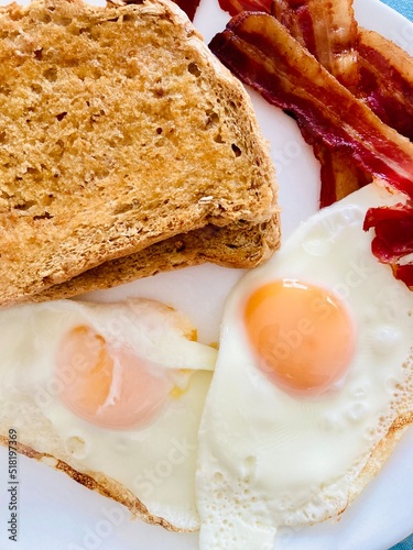 Breakfast with fried eggs, crispy streaky bacon and wholemeal toast
