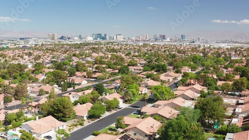 Aerial shot of Las Vegas residential homes with casino strip skyline and airport