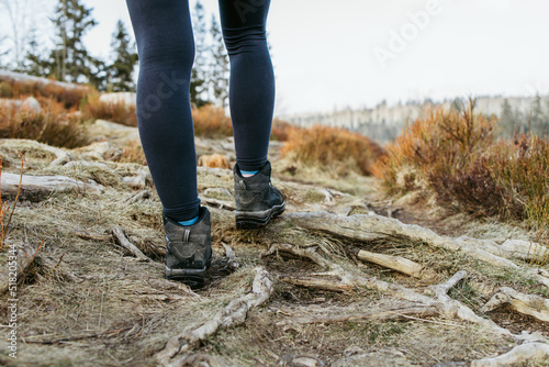 Hiking outdoors. Close-up of a girl's legs in hiking shoes in nature. Active recreation in nature. Travel on foot