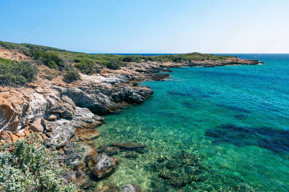 Amazing shot of a sea coast with clear blue water and stones in the foreground.