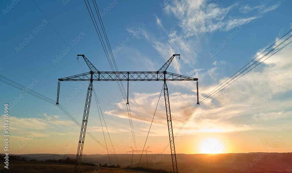 High voltage tower with electric power lines at sunset. Transmission of electricity