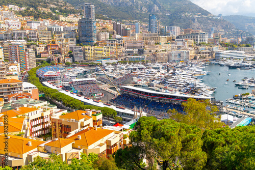 Luxury yachts line the harbor during Grand Prix Race day at Monte Carlo, Monaco, with the mountains, city and casino in view along the coast.