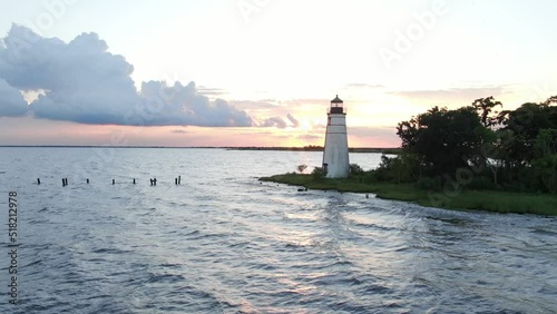 Drone shot slow pan right of lighthouse at sunset near lake overwater on Lake Pontchartrain photo
