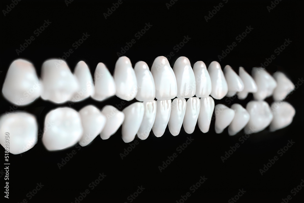 a row of white dentures on a black background. teeth in perspective a row of white dentures on a black background. teeth in perspective