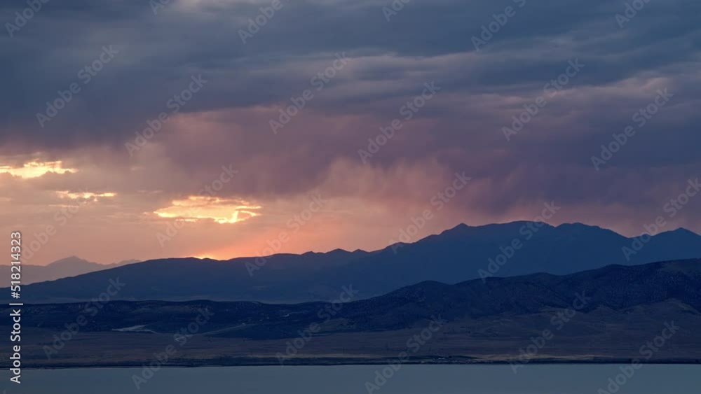 Sunset timelapse as rainstorm moves over the mountains looking past Utah Lake during summer monsoon. Sunset timelapse as rainstorm moves over the mountains looking past Utah Lake during summer monsoon.