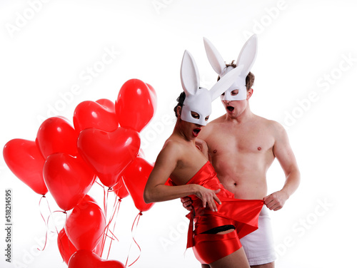 bunny with heart. Couple in love. Red balloonns. Sensual. Man and woman posing studio. Erotica.  photo