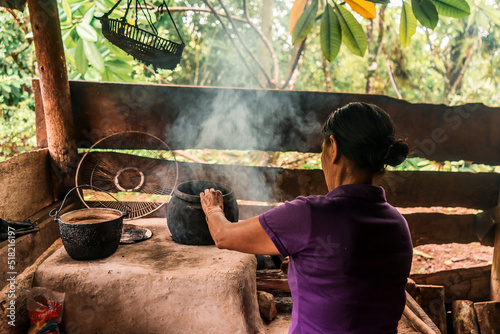 Latin grandmother with arms cooking in pots on the stove at home in Nueva Guinea Nicaragua