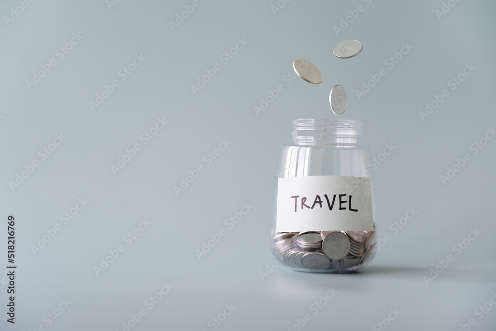 Savings coins jar for travel and coins drop from top concept. Savings coins jar for travel and coins drop from top concept.