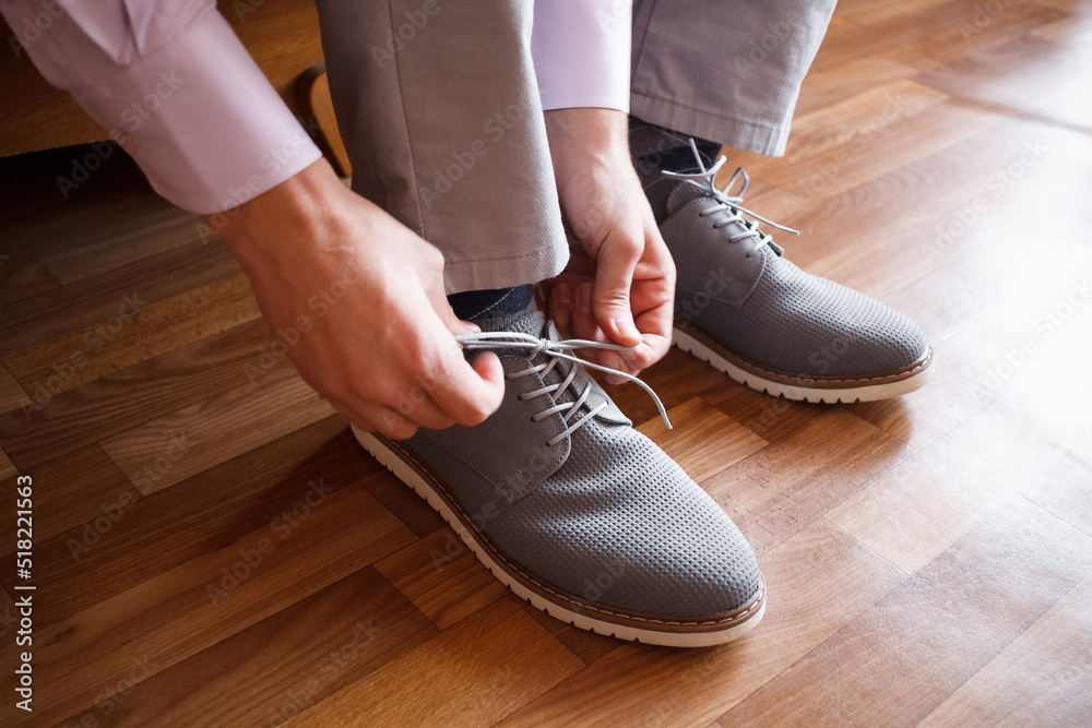 A man put on grey shoes A man put on grey shoes