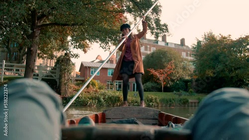 woman is rotating a small boat in a river with a lot of effort photo