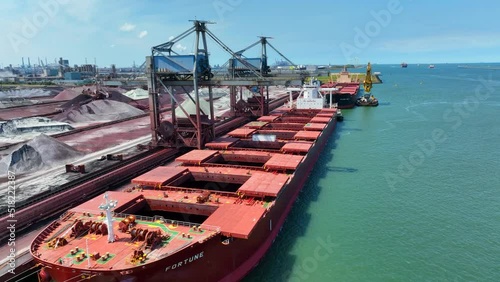 Bulk Carrier Ship Offloading Cargo By Crane for Processing photo