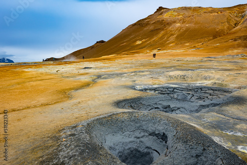 Bright blue holes with bubbling sulphur mud in geothermal area in Northern Iceland