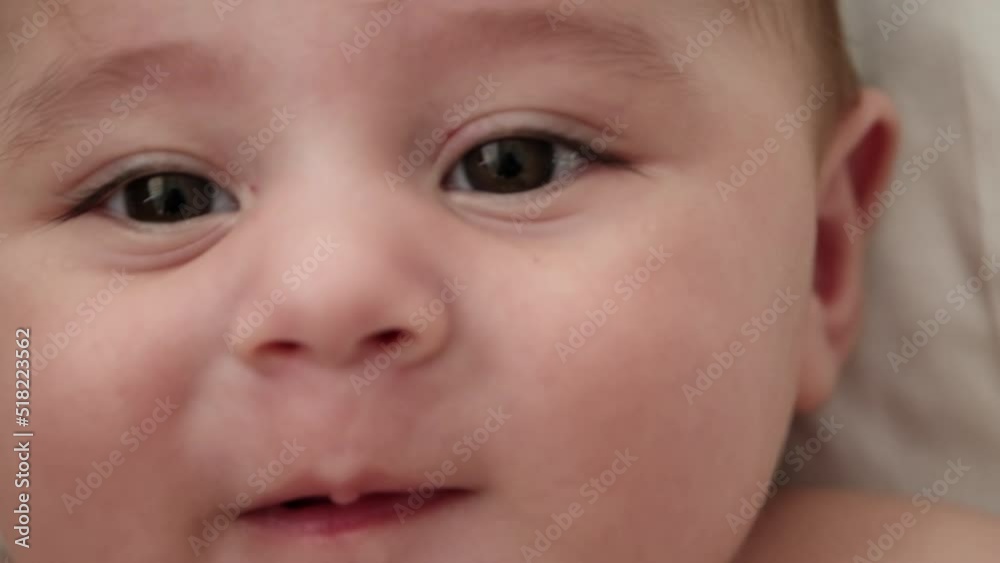 Cute little baby boy, relaxing in bed after bath, smiling happily, daytime. Looking at camera Cute little baby boy, relaxing in bed after bath, smiling happily, daytime. Looking at camera