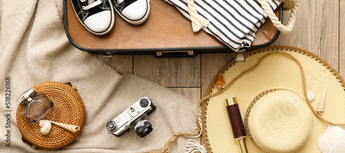 Clothes and accessories for travelling on wooden background