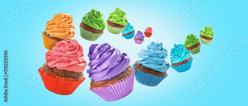 Many flying birthday cupcakes on blue background