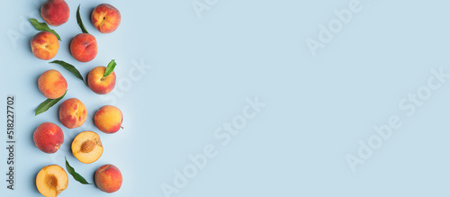 Many ripe peaches on light blue background with space for text