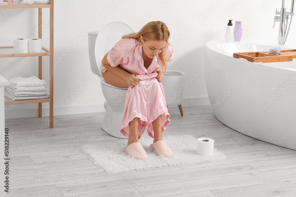 Mature woman with diarrhea sitting on toilet bowl in bathroom Stock ...