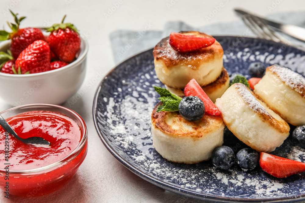 Plate with cottage cheese pancakes, berries and mint leaves on table, closeup