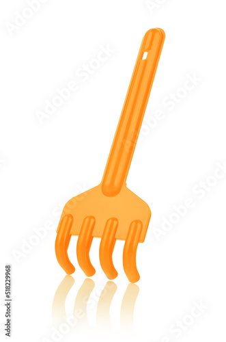Orange plastic rake isolated on a white background, with reflection, close-up. Children's toys for playing in the sandbox. Games for early child development