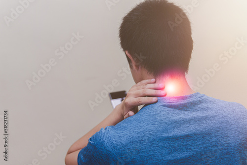 Man playing smartphone suffering from neck pain standing on white background, health problem and people concept