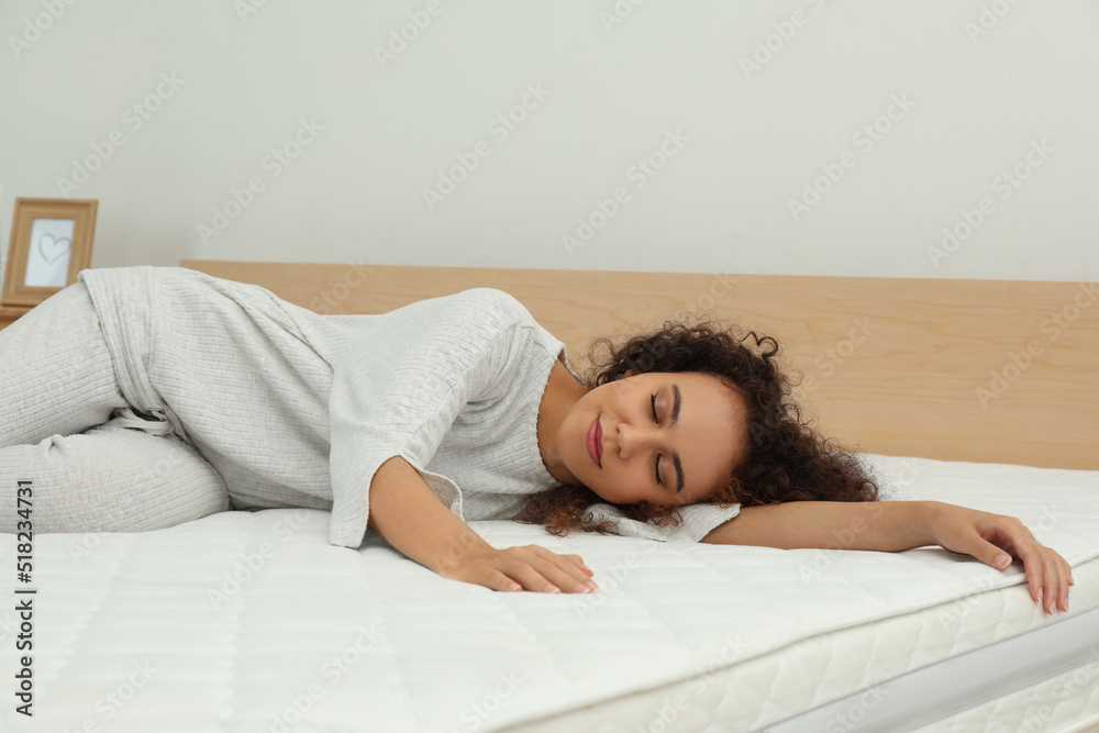 Young African American woman sleeping on bed with comfortable mattress at home Young African American woman sleeping on bed with comfortable mattress at home