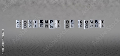 contempt of court word or concept represented by black and white letter cubes on a grey horizon background stretching to infinity