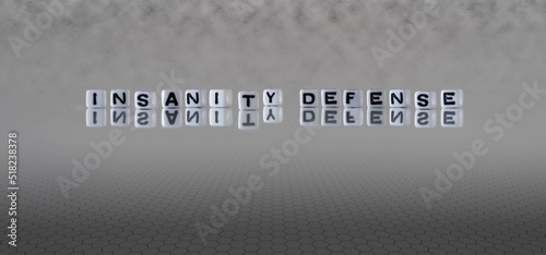 insanity defense word or concept represented by black and white letter cubes on a grey horizon background stretching to infinity