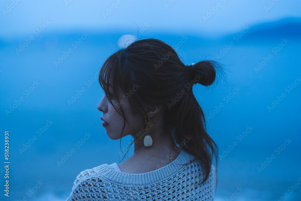 夕暮れの海を散策する女性 夕暮れの海を散策する女性