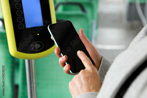 Konstfotografi Woman with smartphone near contactless fare payment device in public transport,