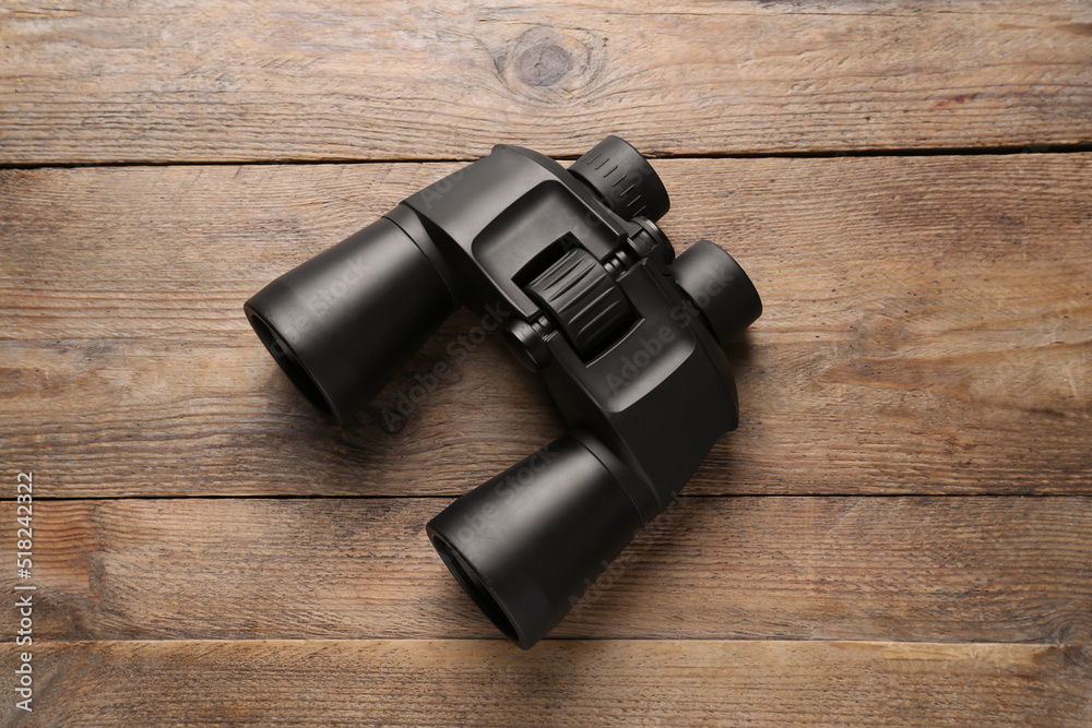 Modern binoculars on wooden table, top view Modern binoculars on wooden table, top view