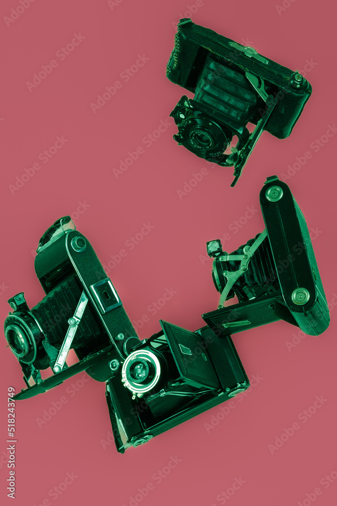 Coloured vintage film bellow cameras on plain background