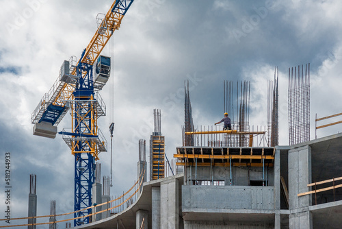Lifting tower crane at housing construction.