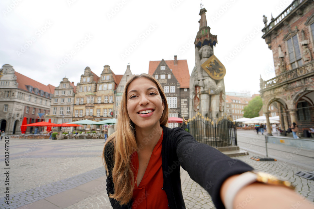 Beautiful woman takes self portrait in Bremen Market Square with Roland statue, Bremen, Germany