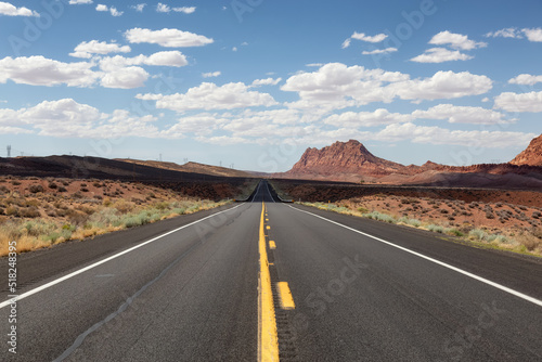 Scenic Road in the Dry Desert with Red Rocky Mountains in Background. Near Page, Arizona, United States of America. Adventure Travel