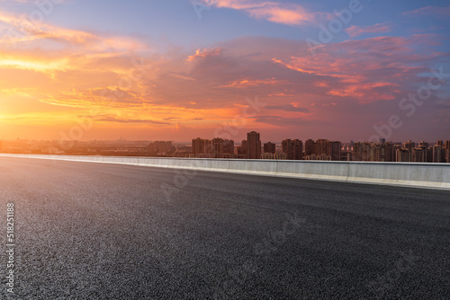 Asphalt road and modern city skyline with colorful sky clouds at sunset in Suzhou, China. high angle view.