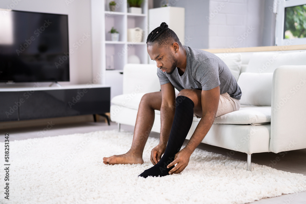 Man Putting On Medical Compression Stockings Man Putting On Medical Compression Stockings