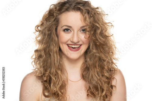 Attractive blonde woman with curly beautiful hair smiling on white background